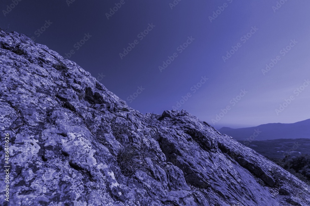 low mountains in mist toned in trendy Very Peri pantone color of the Year 2022. nature background