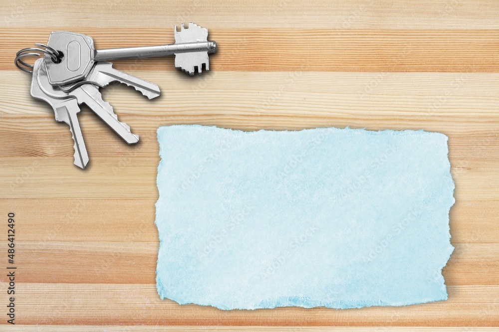 Key and torn paper on the wooden desk