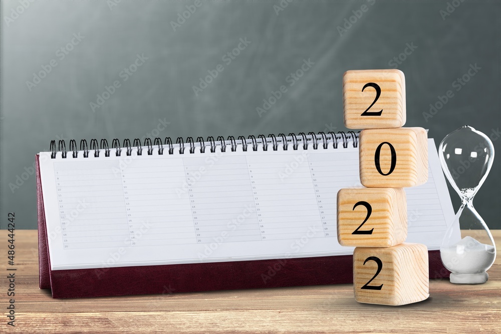 2022 mockup notepad and cubes wooden on table background, plans for New Year 2022