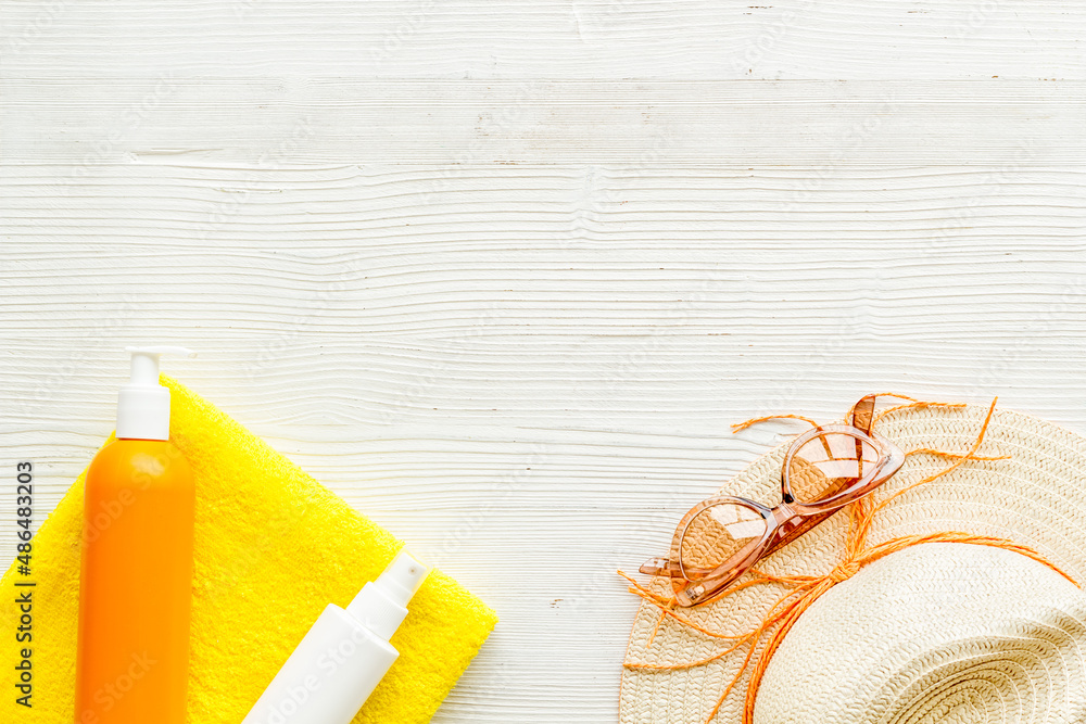 Summer beach vacation concept with straw hat and bottles od sunscreen