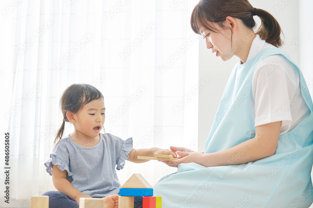 積み木で遊ぶ子供と保育士