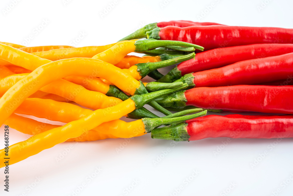 Fresh yellow and red peppers on white background