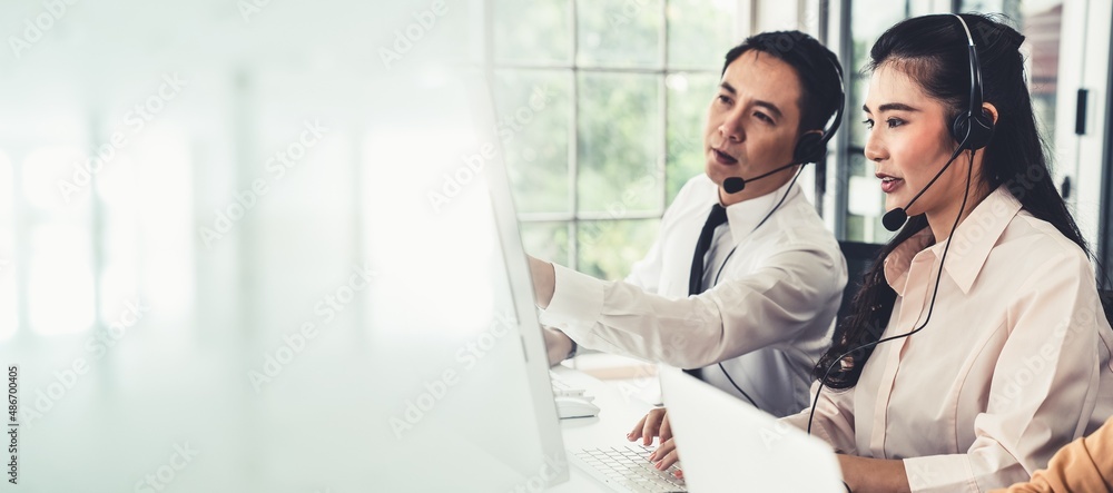 Business team wearing headset working actively in office . Call center, telemarketing, customer supp