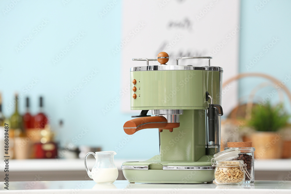 Modern coffee machine on table in kitchen