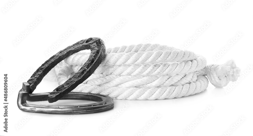 Horseshoes and rope on white background