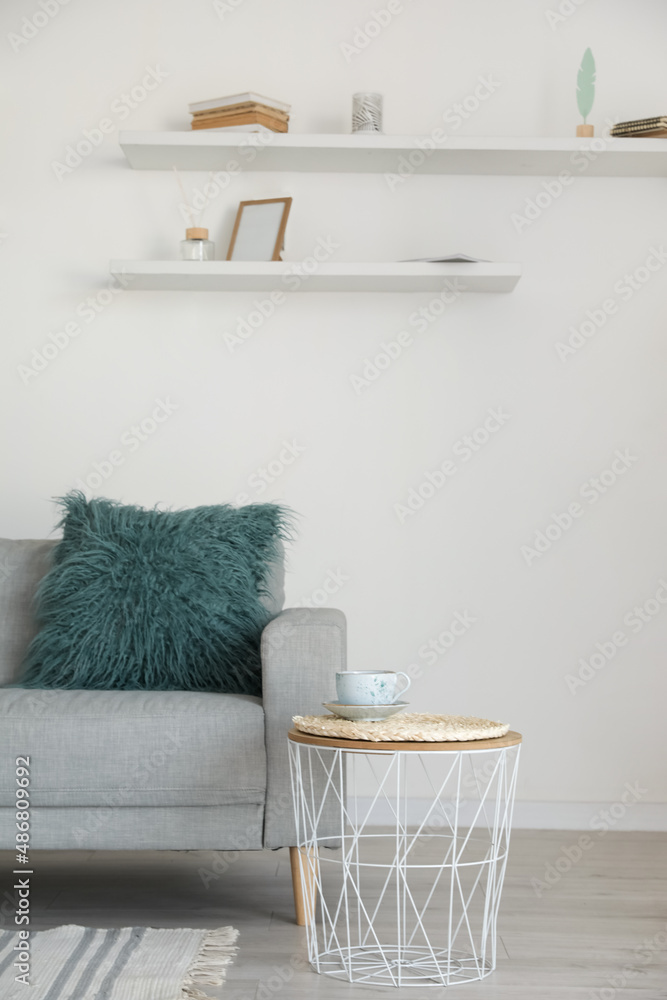 Stylish grey sofa with table in modern interior of living room