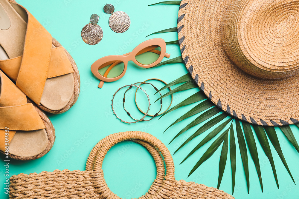 Composition with beach accessories, shoes and palm leaf on color background