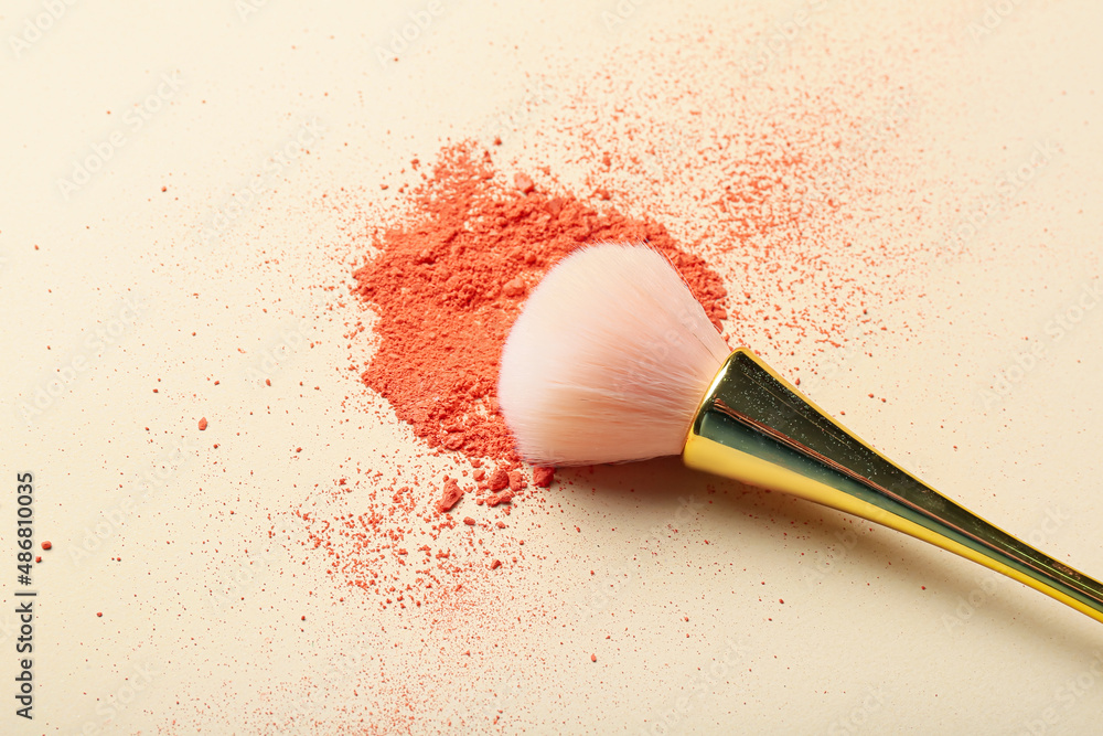 Makeup brush and loose eye shadow on light background