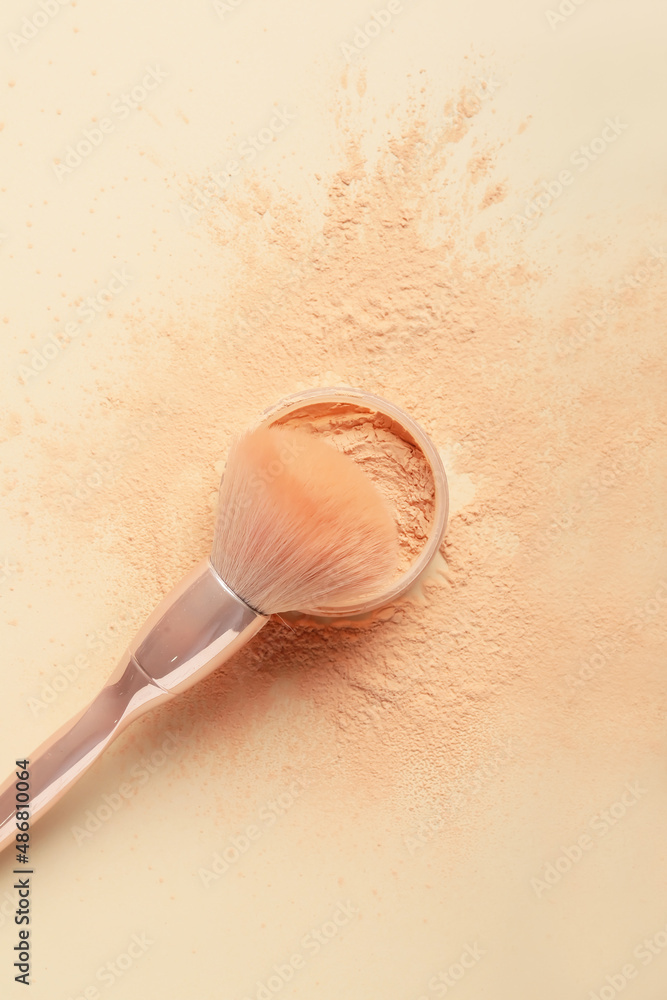 Makeup brush and loose powder on light background