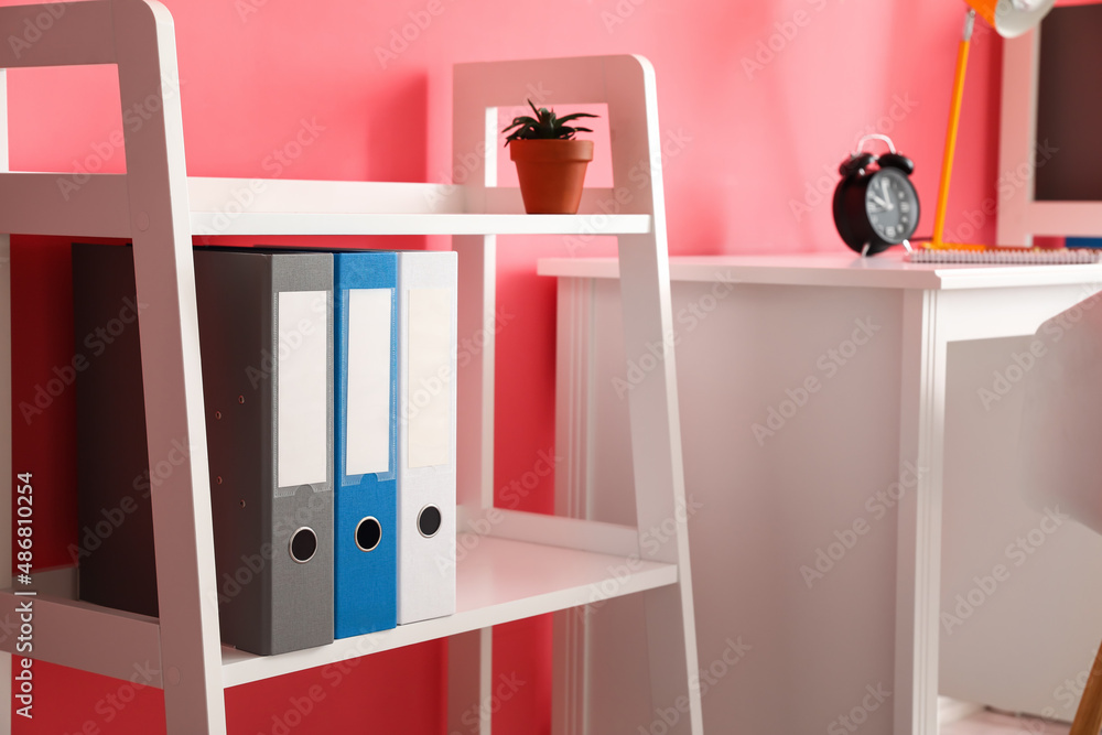 Shelf unit with folders near color wall