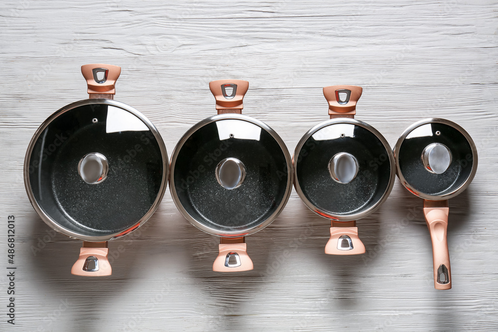 Set of cooking pots and saucepan on grey wooden background