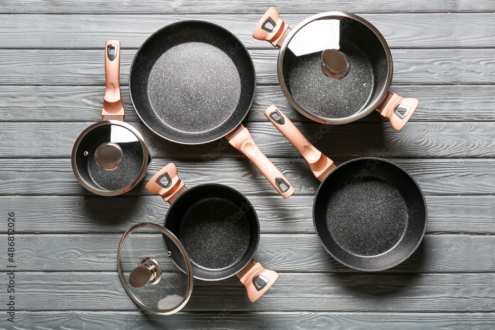 Set of different kitchen utensils on grey wooden background