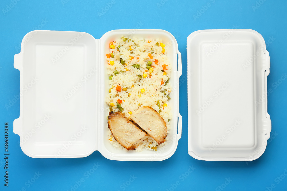 Lunch boxes with food on color background