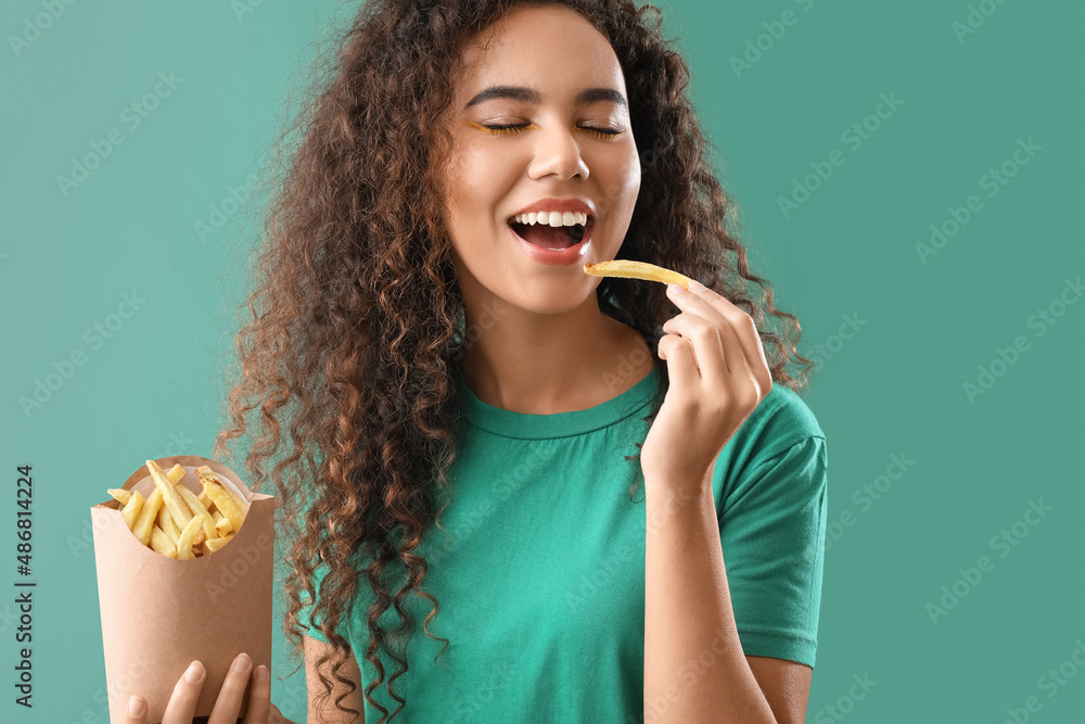 Young African-American woman with french fries on green background