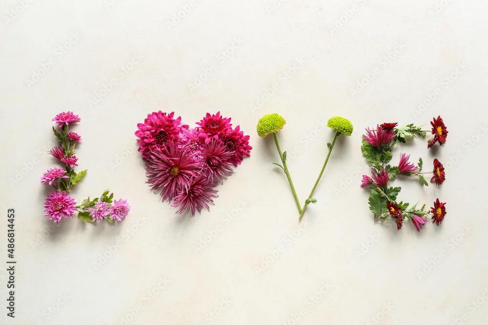 Word LOVE made of chrysanthemum flowers on light background