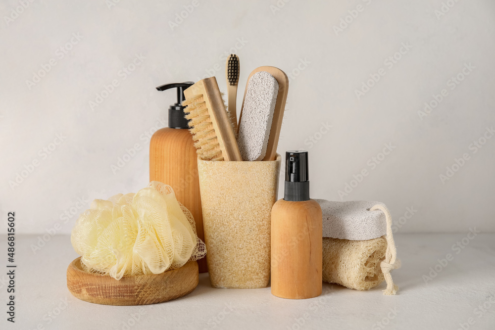 Different bath accessories and cosmetics on light background