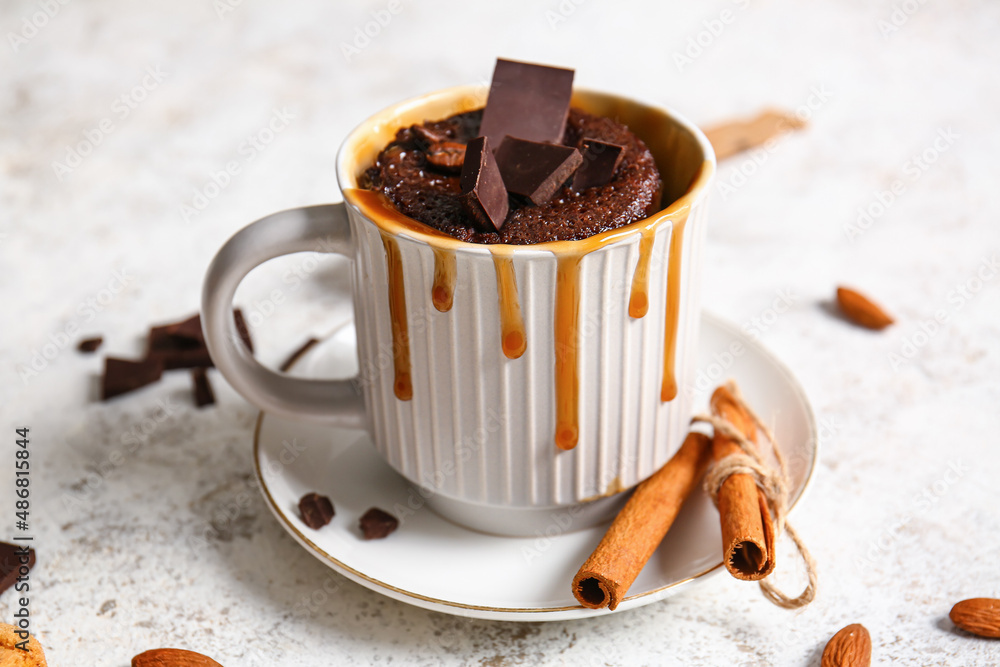 Cup with tasty chocolate brownie on light background