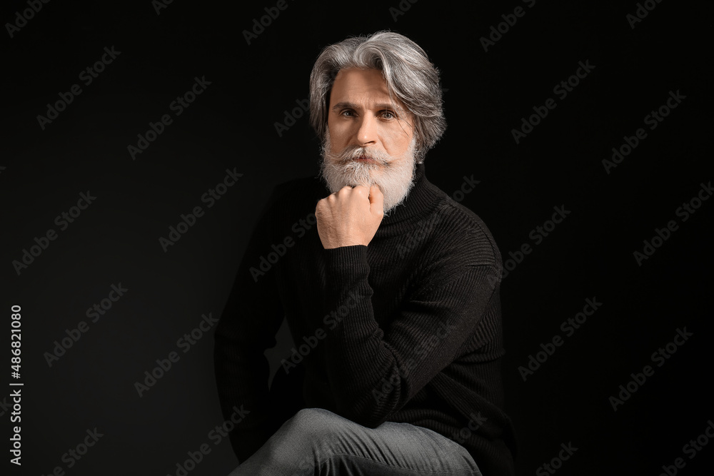 Portrait of handsome mature bearded man on dark background