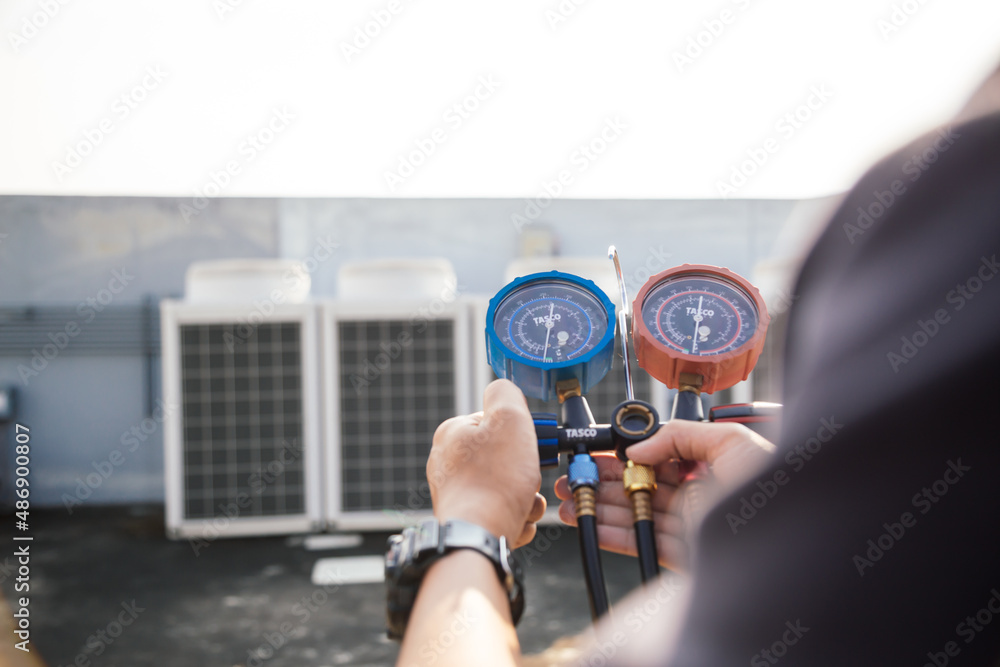 Technician is checking air conditioner ,measuring equipment for filling air conditioners.Cooling sys