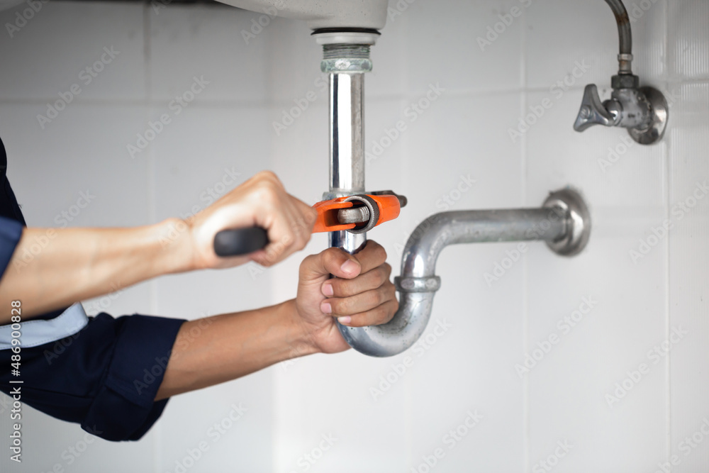 plumber at work in a bathroom, plumbing repair service, assemble and install concept.