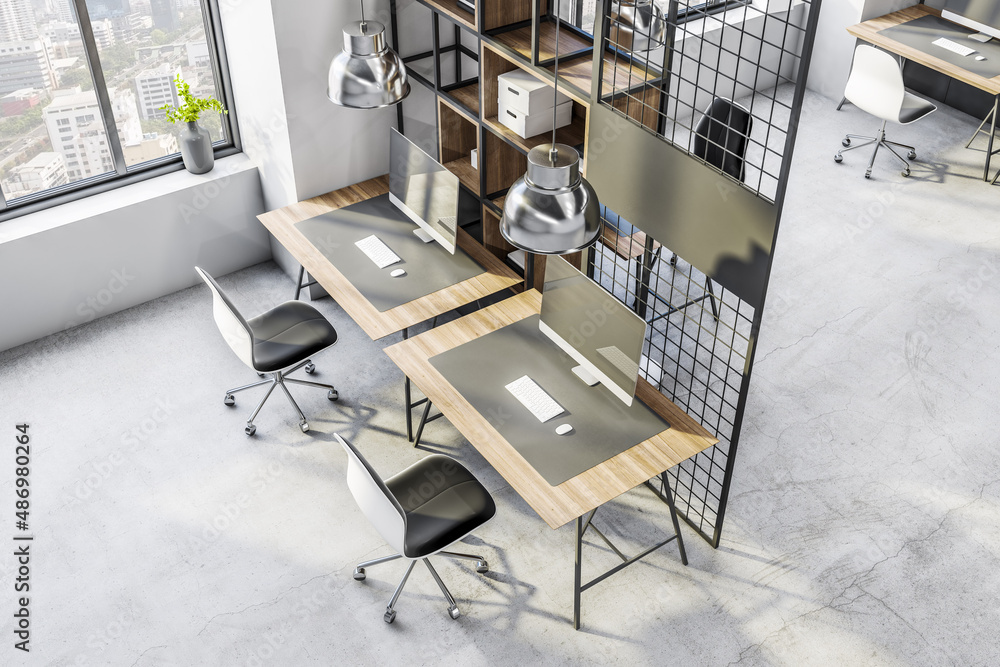 Top view on spacious work places background in loft interior design office with city view, computers