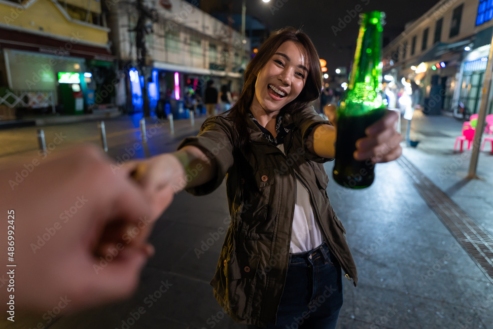 Portrait of Asian woman traveler hold boyfriends hand, walk on street. 