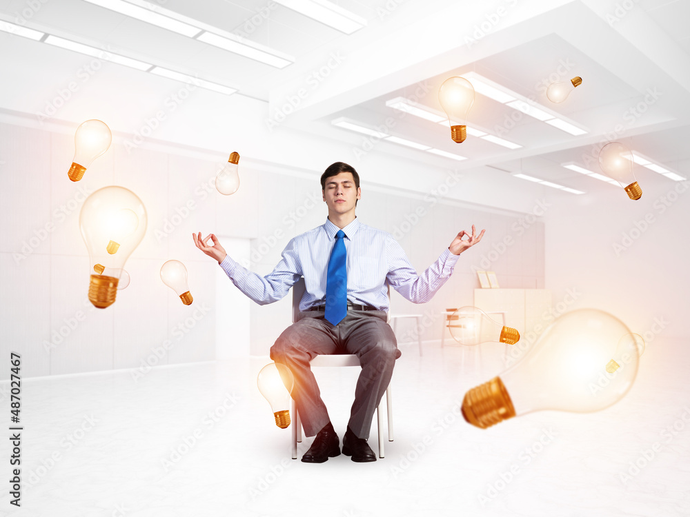 young businessman meditating in the office