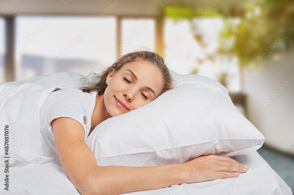 Young woman sleeping in comfortable bed with silky linens at home