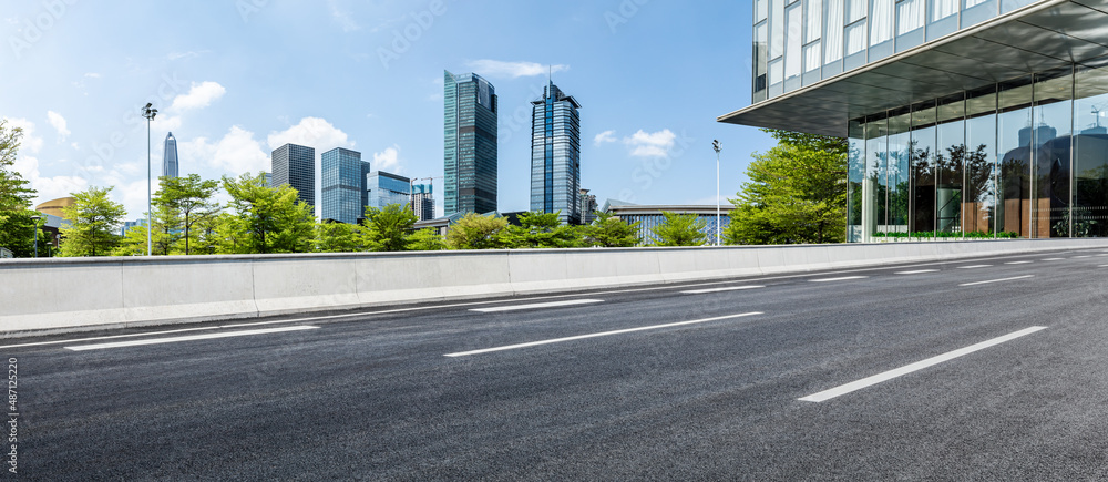 中国深圳的沥青道路和城市天际线，以及现代化的商业建筑。