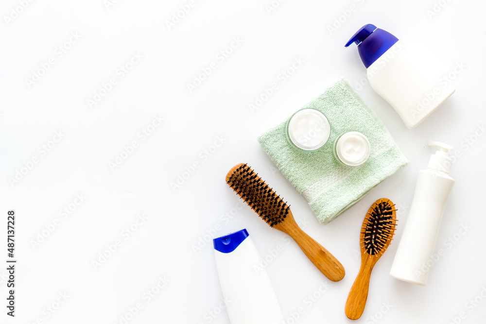 Flat lay of cosmetics for hair care with comb