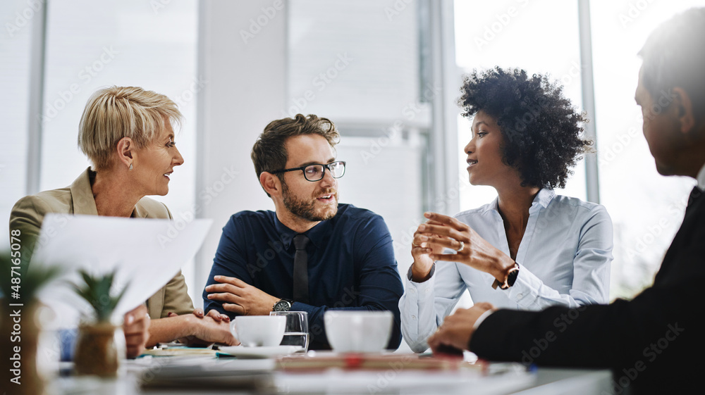 Give us difficult and well show you easy. Shot of a group of businesspeople sitting together in a me