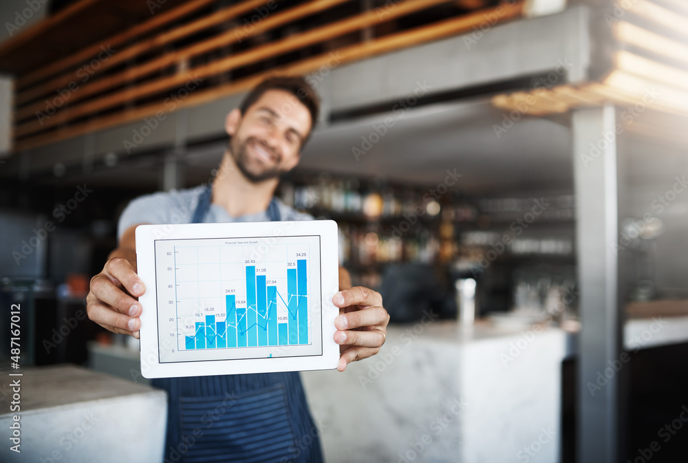 The figures have never looked this good. Portrait of a young man holding a digital tablet with a gra