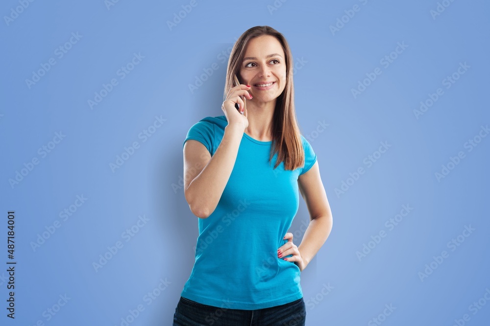 Smiling student girl is holding mobile phone in hand on a background