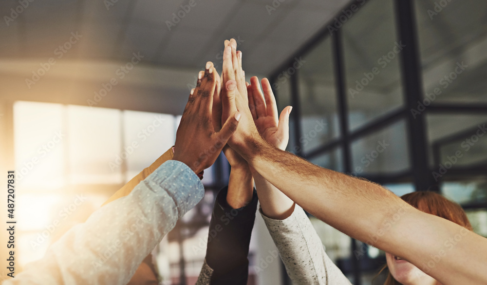 We always win. Shot of a group of colleagues giving each other a high five.