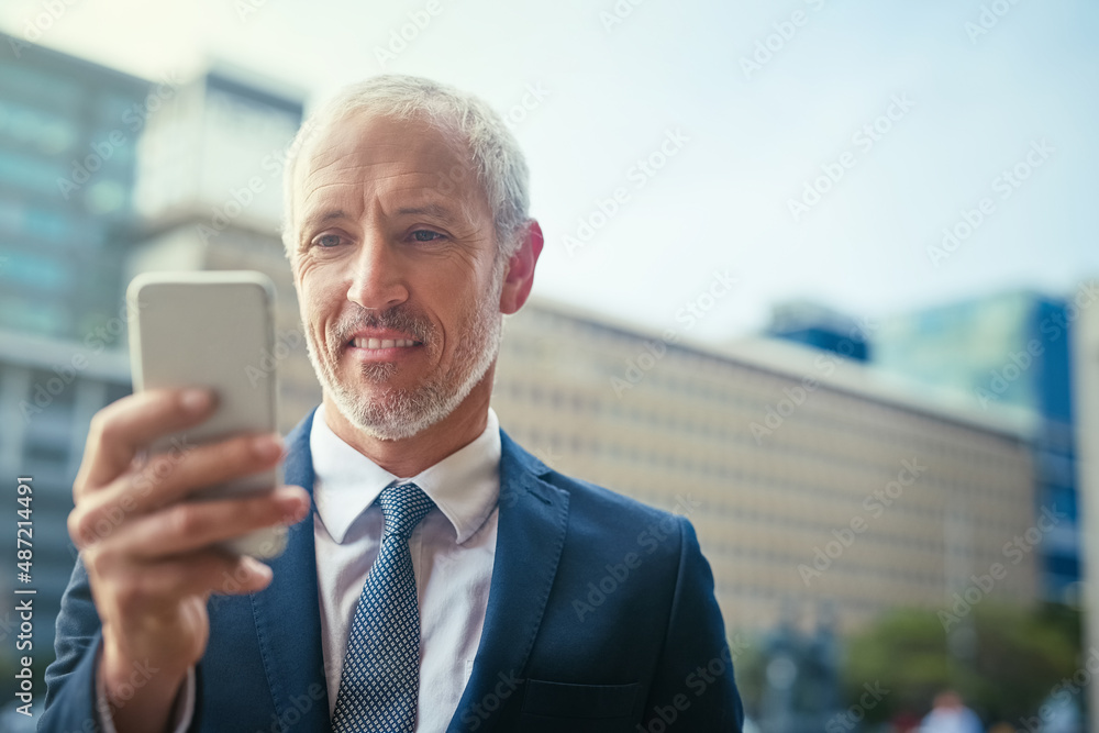 让他的手指说话。一个自信的商人站着用手机的镜头