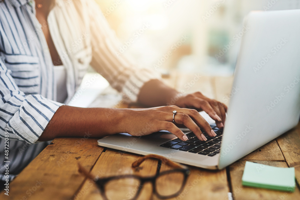 Youll want to read this. Cropped shot of a woman using her laptop on a wooden table.