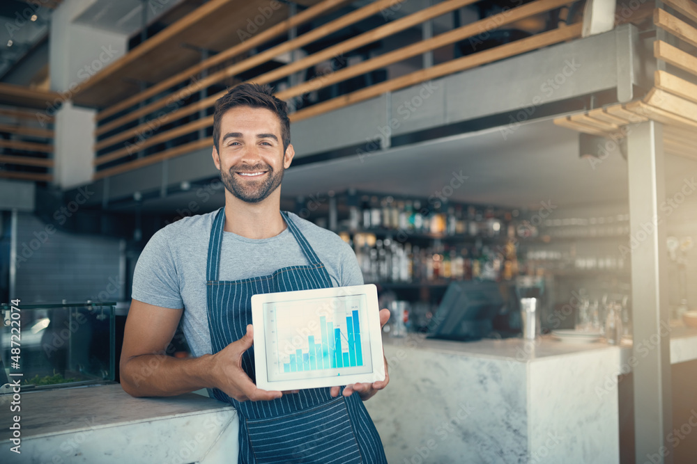 Investing your passion pays off. Portrait of a young man holding a digital tablet with a graph on th