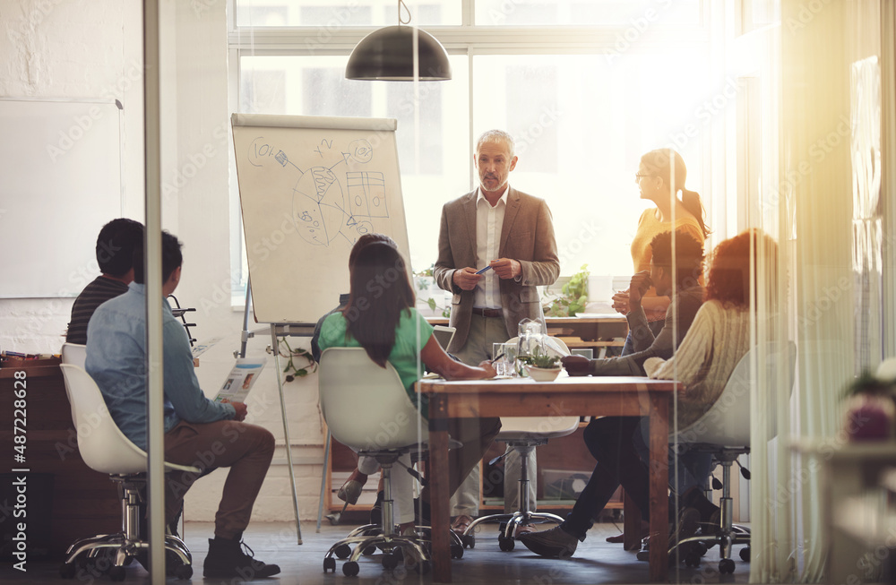 Any questions. Shot of a group of coworkers in a boardroom meeting.