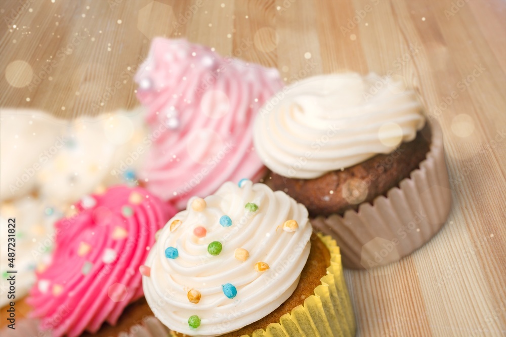 Many different cupcakes with decorations and toppings in a pastry shop concept