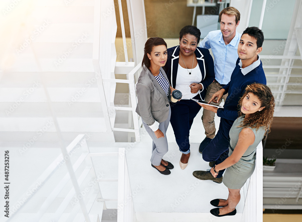 Success is achieved through teamwork. Portrait of a group of coworkers having a meeting in a stairwe