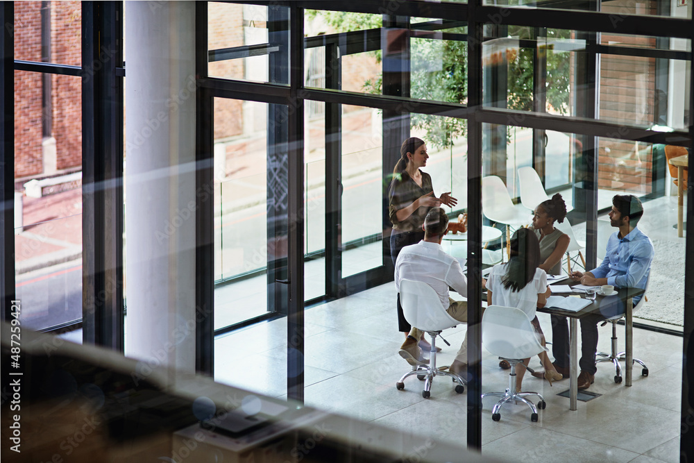 Leading her team through the meeting. Shot of a group of businesspeople having a meeting in a boardr