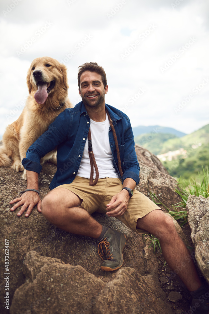 We just love hiking through the mountain. Cropped portrait of a handsome young man and his dog takin