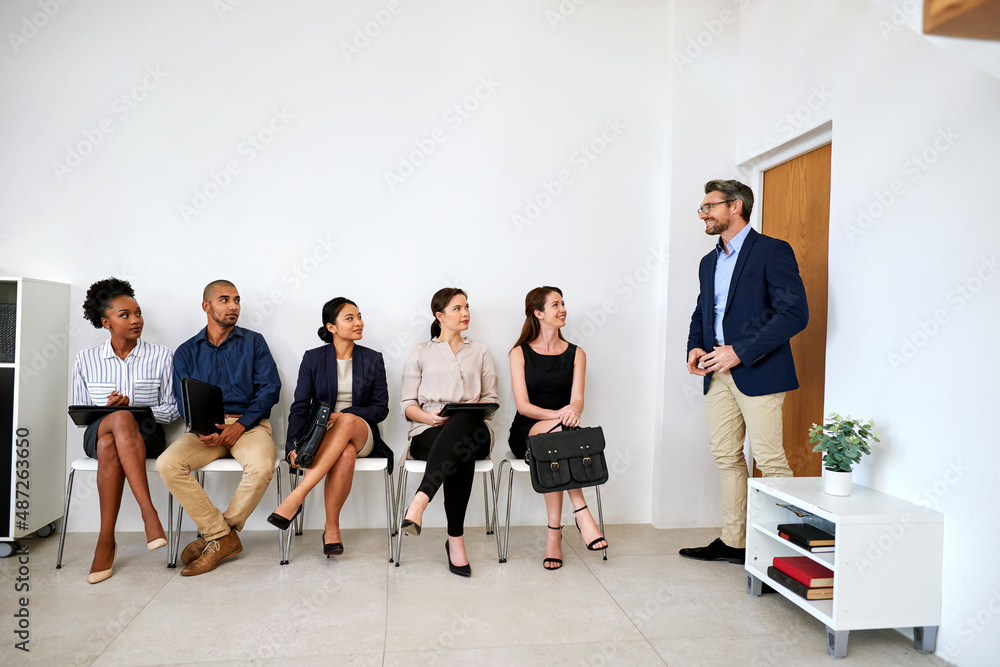 So sorry to keep you waiting. Shot of a group of businesspeople seated in line while waiting to be i