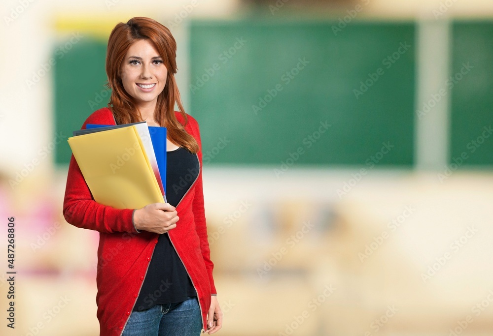 Back to school. Positive teacher woman standing with notebook in school class. Learning education ca