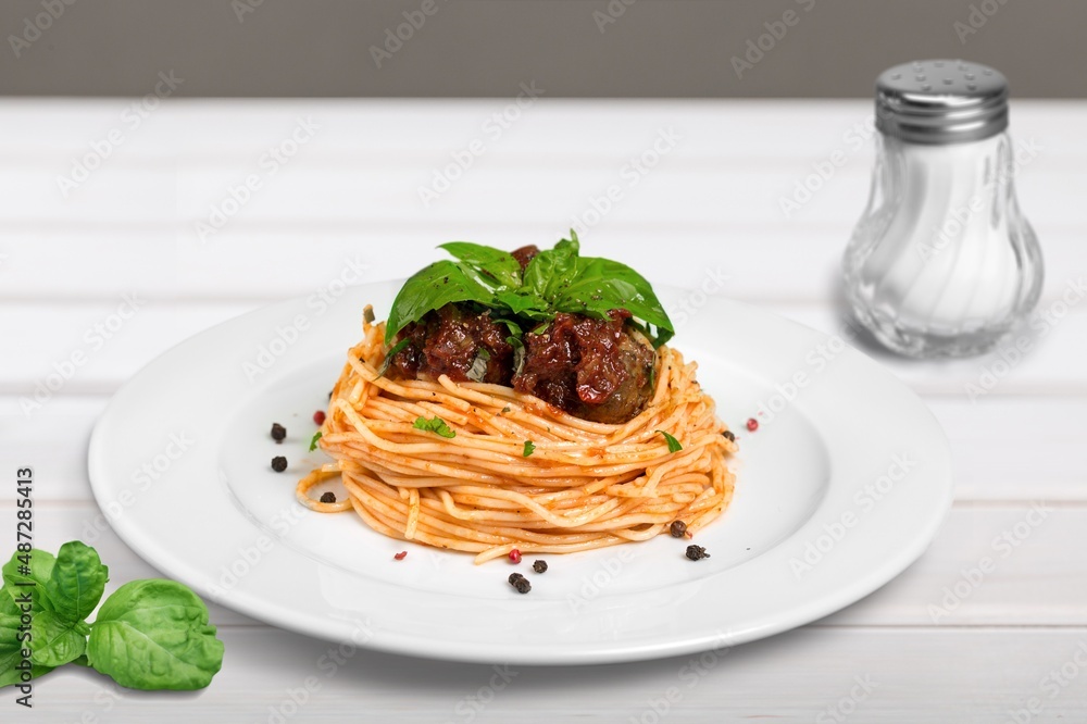 spaghetti pasta with meatballs and sauce, basil, cheese