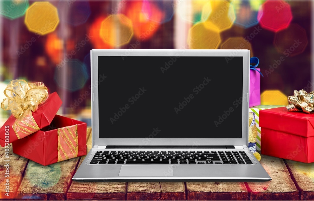 Blank screen on laptop computer Merry Christmas table background. Xmas online