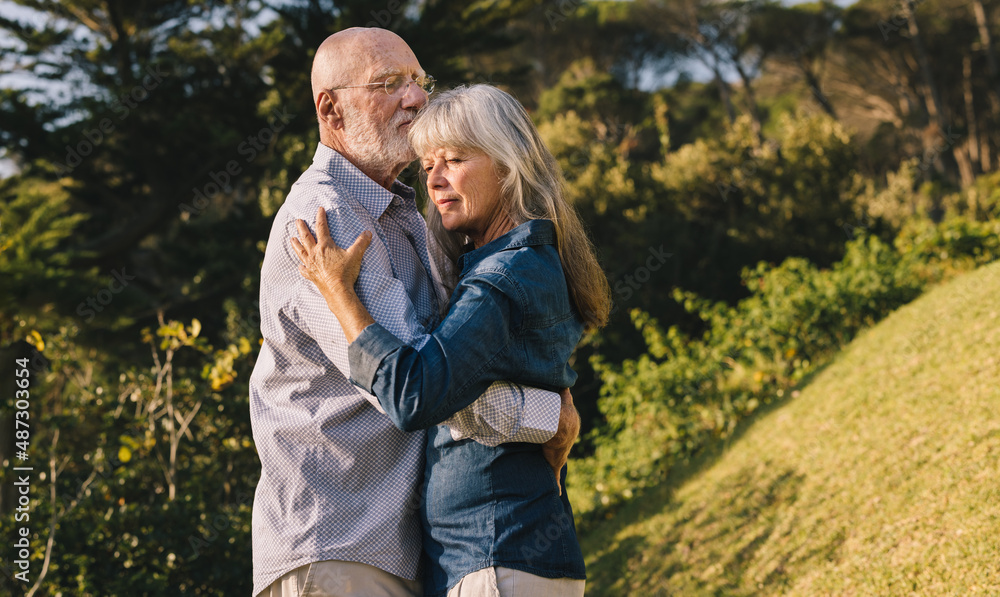 Mature couple slow dancing in a park