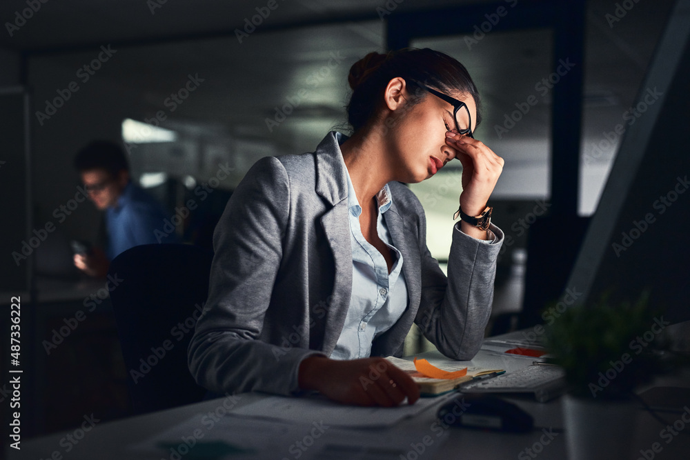 Its been a long day. Shot of a young attractive businesswoman working late at night in a modern offi