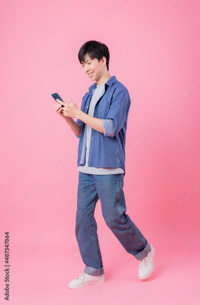 Young Asian man posing on pink background