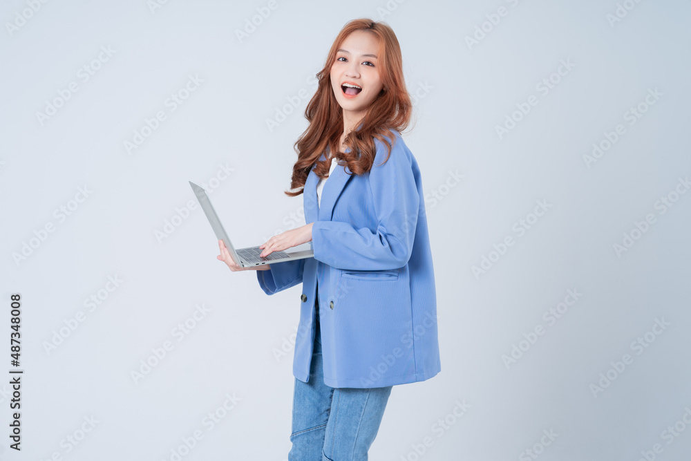 Young Asian businesswoman using laptop on white background